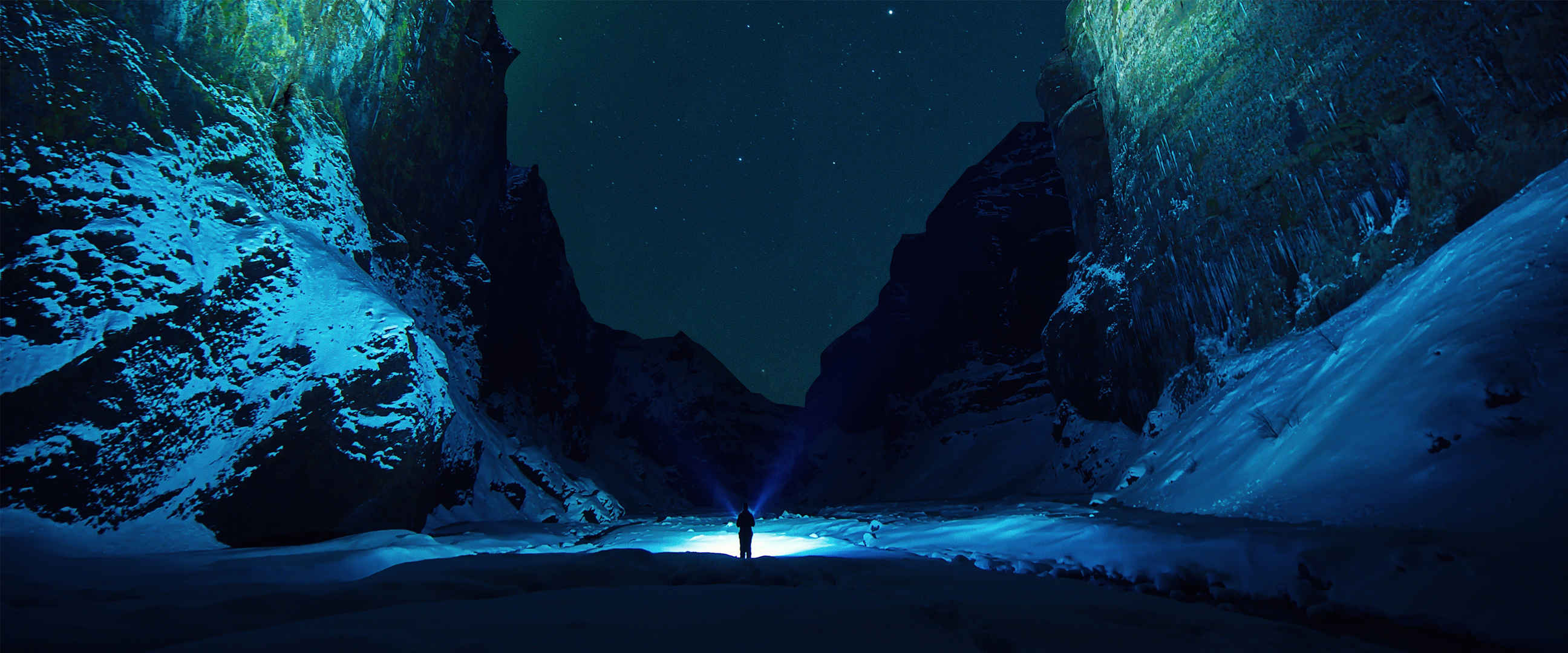 深夜雪山里一个人拿着手电筒照亮前途孤独图片